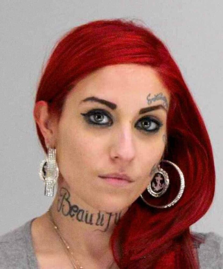 mugshot of an attractive red haired woman with golden earrings