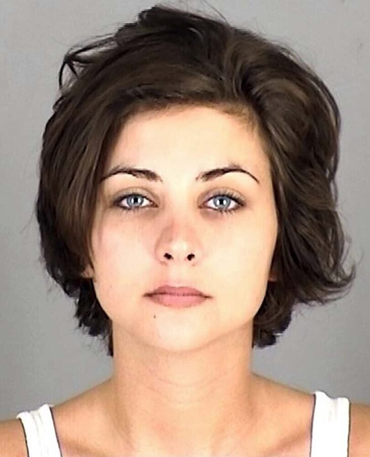 a mugshot of a cute girl with pretty blue eyes and short brown hair
