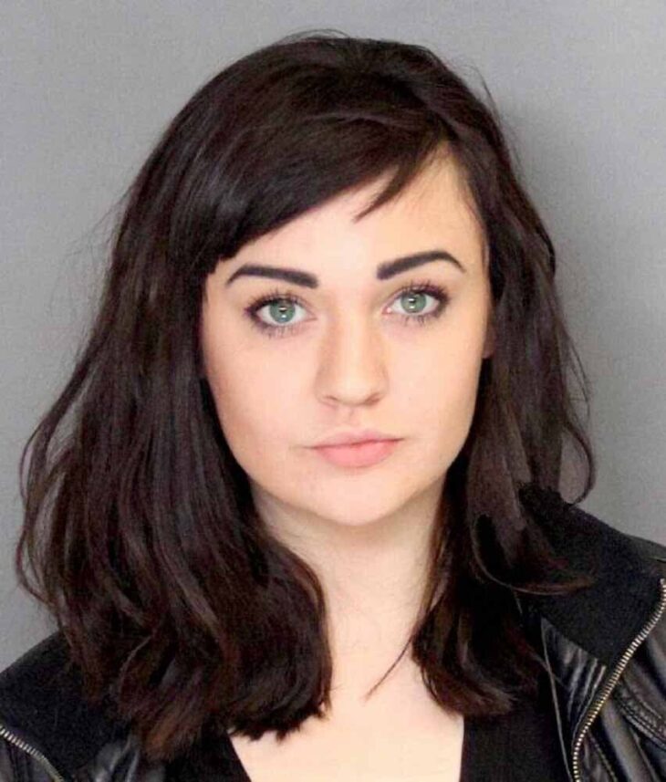 mugshot of a dark haired and blue eyed beautiful woman